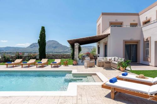 a villa with a swimming pool and a patio at Majestic View Villa in Kolimbia