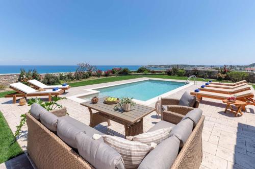 a patio with a pool and chairs and a table at Majestic View Villa in Kolimbia