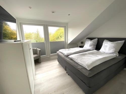 ein Schlafzimmer mit einem Bett und einem großen Fenster in der Unterkunft Moderne, hochwertig ausgestattete Hausscheibe in Sackgassenlage! in Westerholz