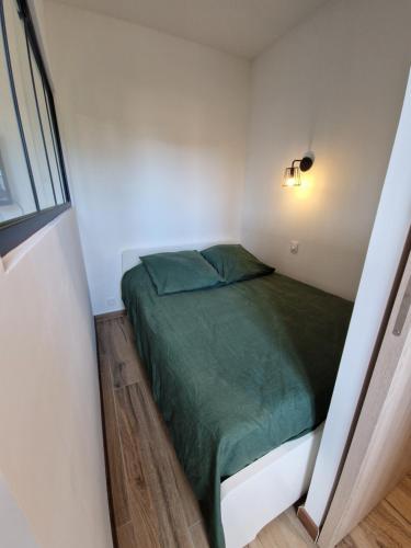 Cette petite chambre comprend un lit vert. dans l'établissement La Terrasse de Bormes, à Bormes-les-Mimosas