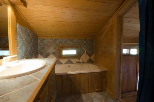 a bathroom with a tub and a sink at Chalet Ferme des Amis in Les Gets