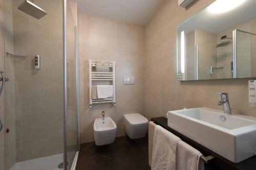 a bathroom with a sink and a toilet and a shower at Hotel Vedig in Santa Caterina Valfurva