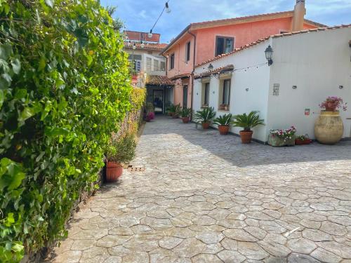 an alley with plants and buildings in a town at Sa Mola in Bonarcado