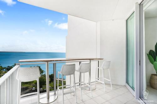 a balcony with chairs and a view of the ocean at Stunning Esplanade Retreat with Ocean Views in Cairns