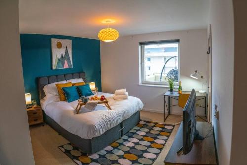 Rueben Suite By Koya Homes - Cardiff في كارديف: غرفة نوم بسرير كبير بجدار ازرق