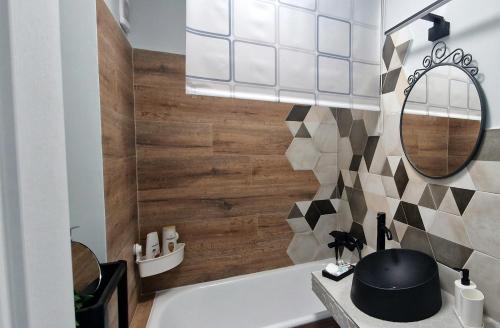 La salle de bains est pourvue d'une baignoire blanche et d'un miroir. dans l'établissement BRB Park Studio, à Cluj-Napoca