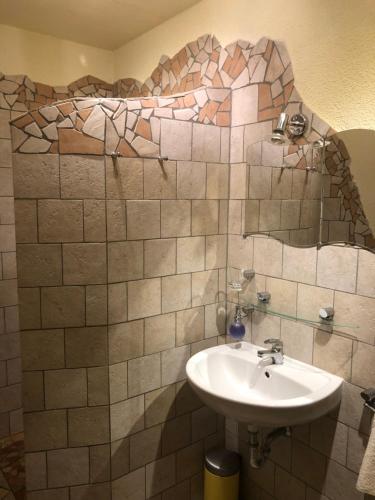 ein Badezimmer mit einem Waschbecken und einer gefliesten Wand in der Unterkunft Ferienwohnung am Nurburgring in Welcherath