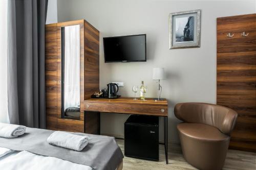 a bedroom with a desk and a bed and a television at Grodzka Royal Apartments in Krakow