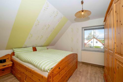 um quarto com uma cama e uma janela em Ferienwohnung Hörselbergblick em Eisenach