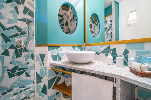 a bathroom with a sink and blue and white tiles at Hotel Yacht Club in Marciana Marina