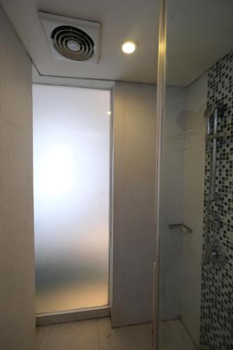 a shower with a glass door in a bathroom at Zia Hotel Kuta in Kuta