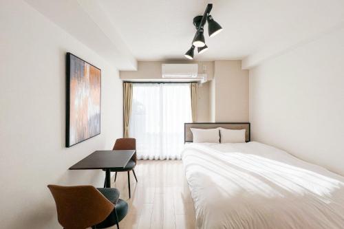 a bedroom with a bed and a table and a desk at Locanda shin-Osaka in Osaka