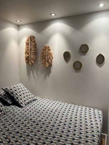 une chambre avec un lit et quelques décorations sur un mur dans l'établissement Appt Ramatuelle - Plage Pampelonne, à Ramatuelle
