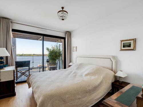 une chambre avec un lit et une vue sur l'eau dans l'établissement Arcachon - Aiguillon - T5 Charmant avec Terrasse, Parking Sécurisé et WiFi - FR-1-319-404, à Arcachon