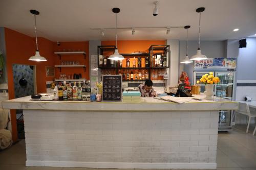 a bar in a restaurant with a person behind the counter at GranDE Classic Pattaya in North Pattaya