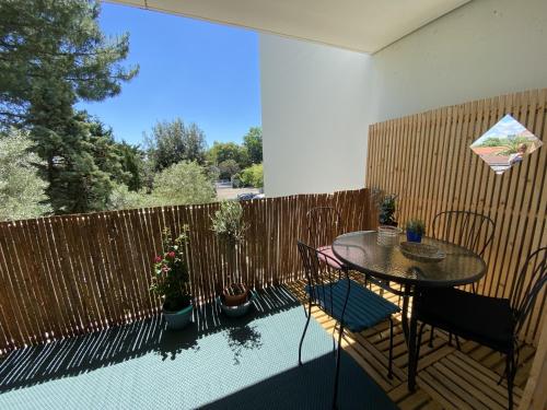un patio avec une table et des chaises et une clôture dans l'établissement T3 avec terrasse, parking et wifi à Arcachon - FR-1-374-163, à Arcachon