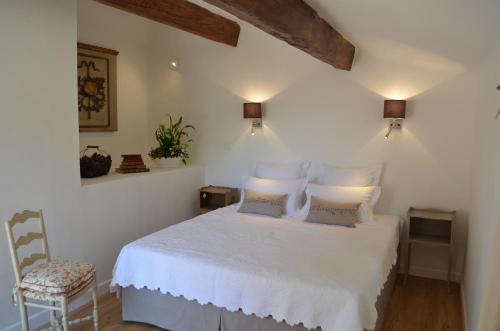 a bedroom with a white bed and a chair at Campagne Chastel in Aix-en-Provence
