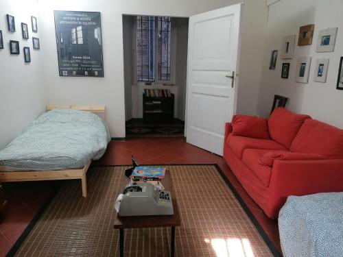 un soggiorno con divano rosso e tavolo di Gallery House a Fermo