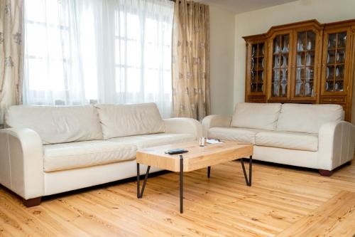 a living room with two white couches and a coffee table at Domek Prezesa in Kazimierz Dolny