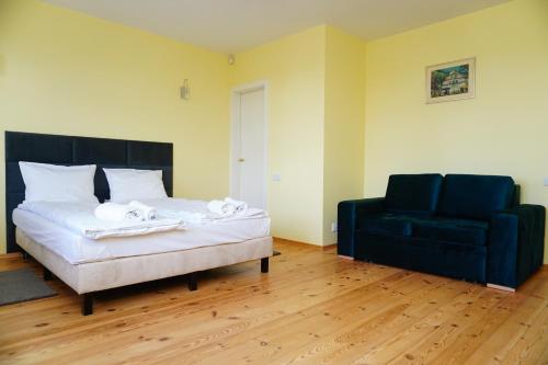 a bedroom with a bed and a blue couch at Domek Prezesa in Kazimierz Dolny