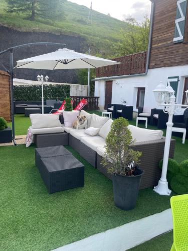 a dog laying on a couch under an umbrella at Hotel Le Blanche Neige in Valberg