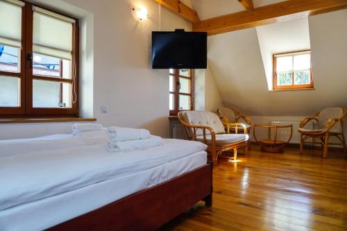 a bedroom with a bed and a tv and chairs at Domek Prezesa in Kazimierz Dolny