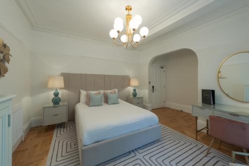1 dormitorio con cama, espejo y lámpara de araña en Florence House Boutique Hotel and Restaurant, en Portsmouth