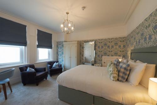 a bedroom with a bed and chairs and a chandelier at Florence House Boutique Hotel and Restaurant in Portsmouth