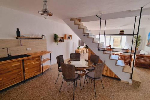 a kitchen and dining room with a table and a staircase at La Tejita Holiday House in La Tejita