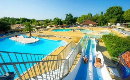 une vue aérienne d'une piscine dans un complexe hôtelier dans l'établissement Camping 4 étoiles RIVAGES DES LANDES anciennement Domaine Eurolac, à Aureilhan