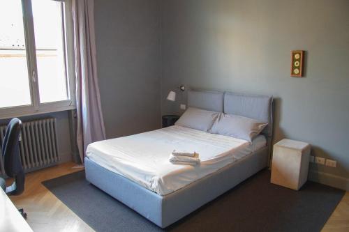 een slaapkamer met een bed met een boek erop bij La Maison du Théâtre in Ravenna