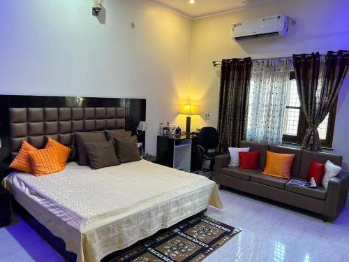Kotdwāra的住宿－Bisht Niwas Homestay，一间卧室配有一张大床和一张沙发