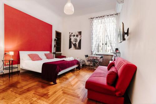 a bedroom with a bed and a red couch at La Casa Del Sole A Mergellina in Naples