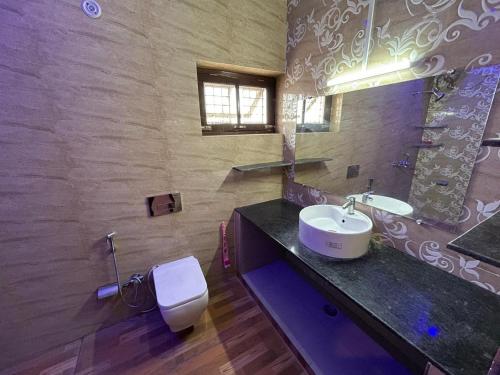 ein Bad mit einem Waschbecken und einem WC in der Unterkunft Bisht Niwas Homestay in Kotdwāra
