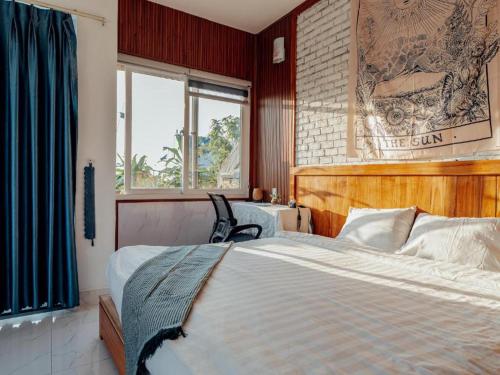 a bedroom with a bed and a table and a window at HA Hero Hoian Pool House in Hoi An