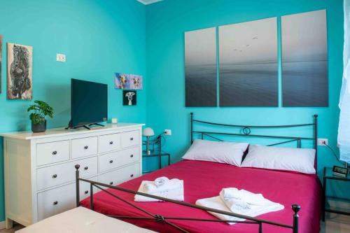 - une chambre avec un lit rouge et un mur bleu dans l'établissement [near Orio center]2BR The quiet and relaxing house, à Azzano San Paolo