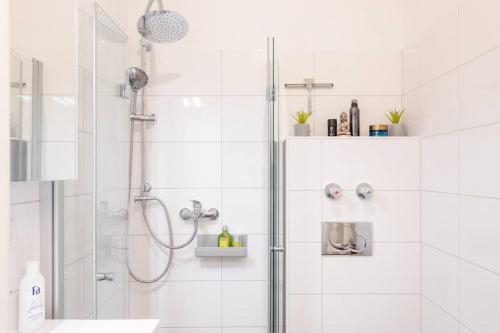 a white bathroom with a shower and a sink at Stilvolles Appartement im lässigsten Viertel in Munich