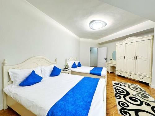 sypialnia z 2 łóżkami i niebieskimi poduszkami w obiekcie 135m2 new apartment 5 rooms with airport pickup w Ułan Bator