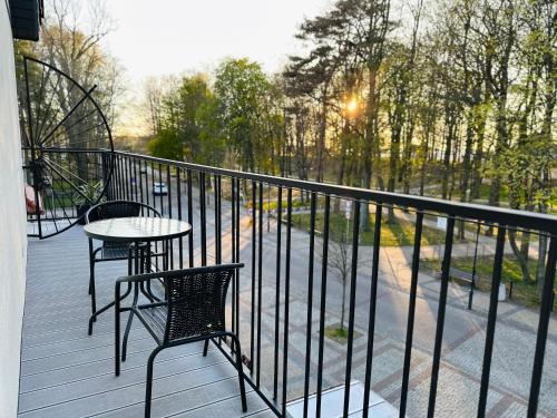 a porch with a table and chairs on a balcony at Fregata in Ustka