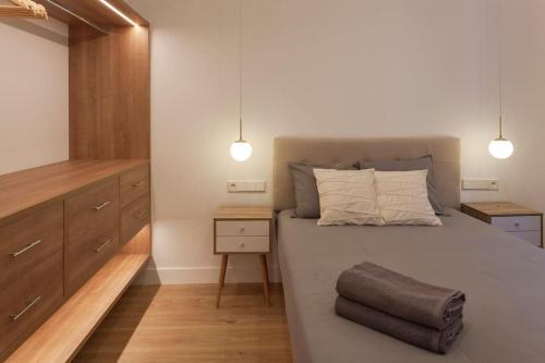 a bedroom with a bed with a nightstand and two lights at Luxury flat Centro I in Madrid