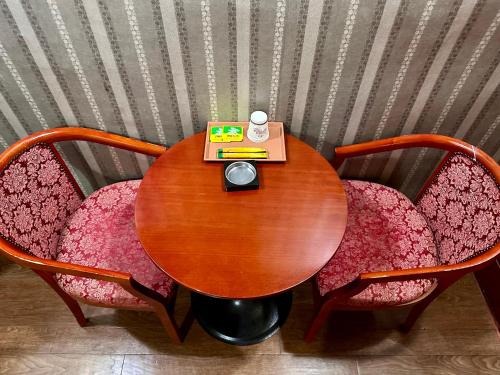 a wooden table with two chairs and a book at Grace Motel in Seoul