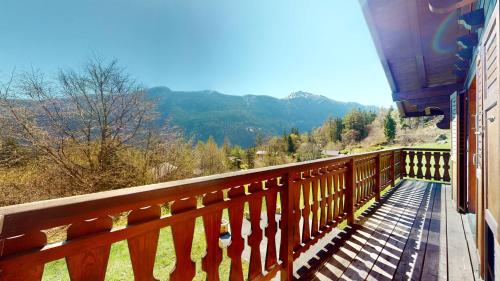 uma varanda de madeira com vista para as montanhas em Warm chalet with a nice exterior in Les Marécottes em Les Marécottes