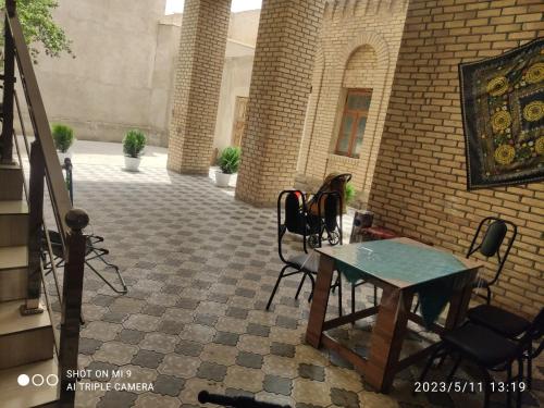 a patio with chairs and a table in a building at KAMIR Guest House in Bukhara