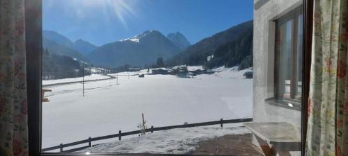 a view of a snow covered field from a window at Ferienhaus Widmann in Kirchberg in Tirol