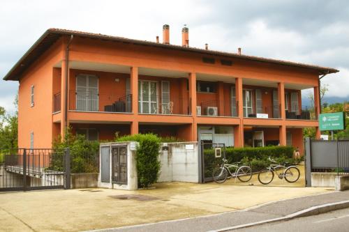ヴァレーゼにあるAgriturismo Familiare I Giardini del Lagoの自転車が目の前に停まっているオレンジハウスです