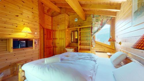 a bedroom with a bed in a wooden cabin at Warm chalet with a nice exterior in Les Marécottes in Les Marécottes
