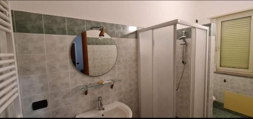 a bathroom with a sink and a mirror and a shower at AFFITTACAMERE DOLCE SOGNO in Cherasco
