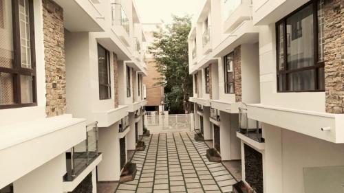 バンガロールにあるGoshen Inn Suites and Serviced Apartmentsの窓のあるアパートメントビルの空廊