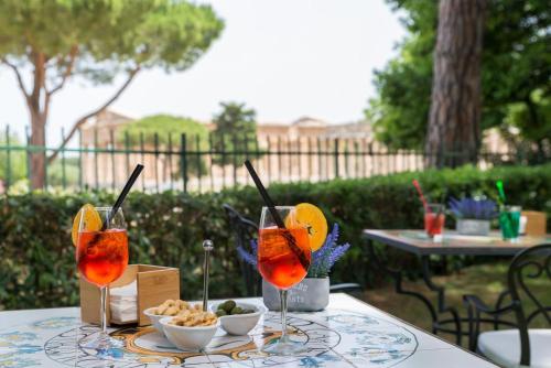 a table with two glasses of juice and snacks on it at Suite Nettuno Paestum in Paestum