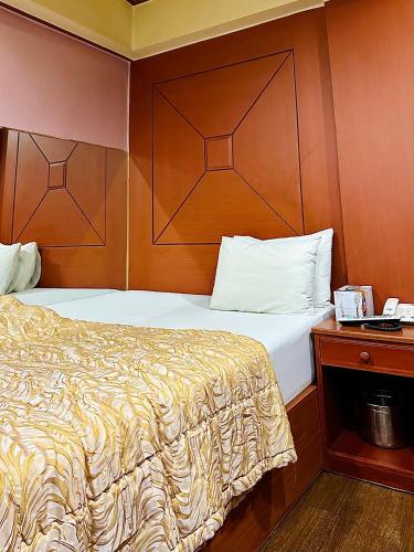 um quarto com uma cama e uma cabeceira em madeira em Grace Motel em Seul